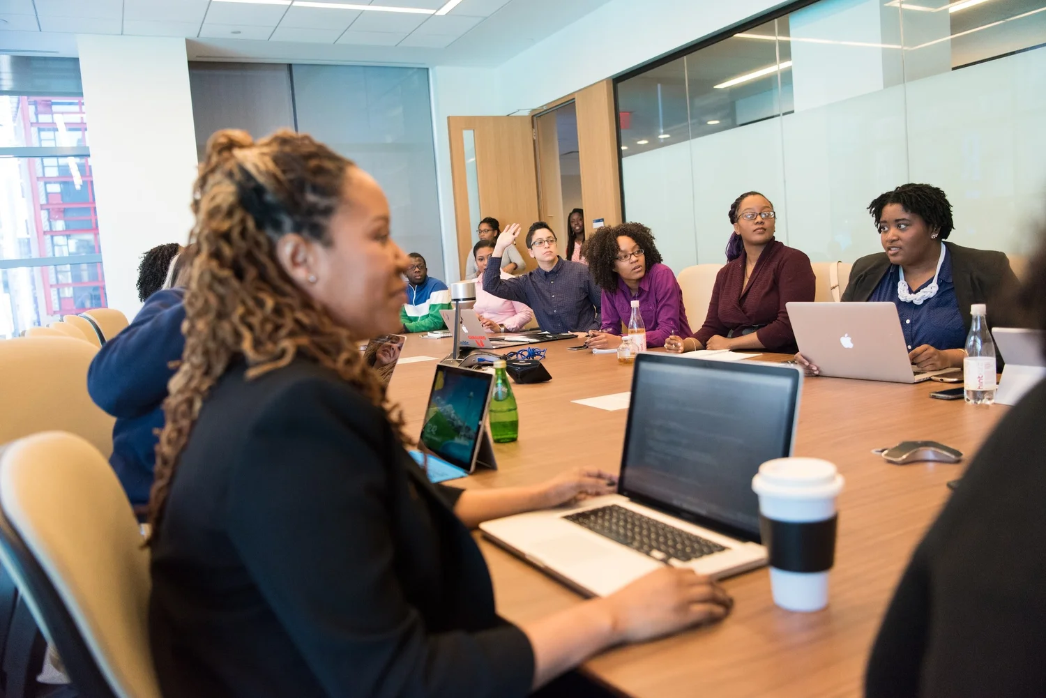 Several folks sit around a conference table. Some wear big smiles and all look very engaged.
